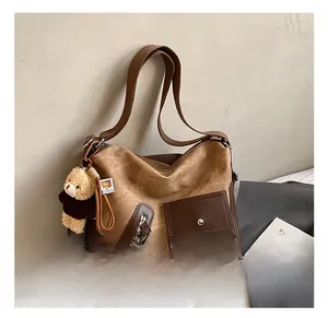 Detail showing the retro canvas tote bag with brown PU leather trim and teddy bear charm