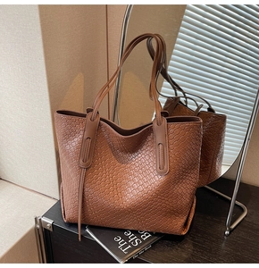 Close-up of brown woven texture and long strap detail on a large capacity tote bag
