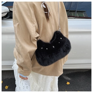Détail du sac à bandoulière en fausse fourrure noire avec étoiles argentées et chaîne