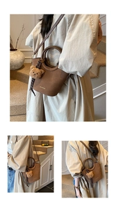 Détail du sac seau vintage marron avec pendentif ours en peluche et poignée en métal
