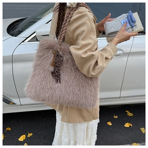 Detail of plush faux fur tote bag in mauve with braided handles and letter charm