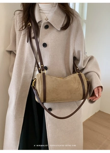 Détail du sac Boston en daim kaki avec bandoulières en cuir brun et zips dorés