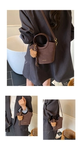 Détail du sac seau marron foncé avec poignées rondes et charmant petit ours peluche