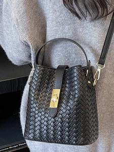 Classic black woven leather bucket bag with top handle and gold lock detail