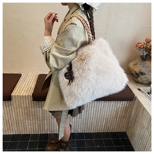 Detail of soft cream beige faux fur tote bag with thick woven rope handle and pendant