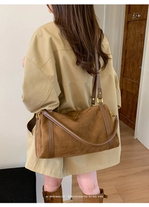 Vue détaillée du sac Boston vintage en daim marron porté en bandoulière sur un modèle