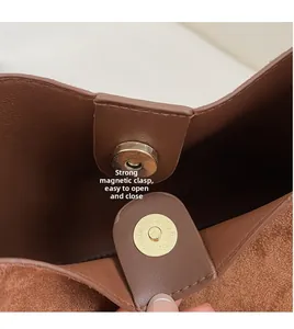 Detail view of strong gold magnetic closure on high-quality brown leather bag