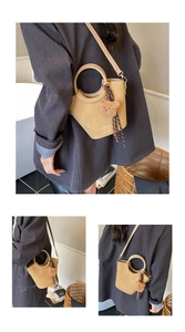 Détail du sac seau kaki avec poignée ronde, breloque ourson et foulard rayé décoratif