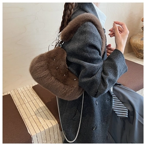 Détail du sac à bandoulière en fausse fourrure marron foncé avec clous argentés