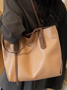 Chic woven tote bag with brown leather handles and spacious interior for women