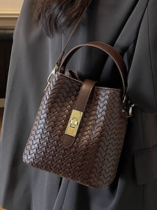 Brown woven bucket bag with gold metal clasp and adjustable shoulder strap for women