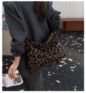 Detailed view of a large leopard print suede tote bag worn with a casual autumn blazer