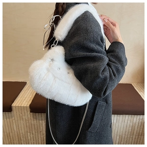 Détail du sac à bandoulière en fausse fourrure blanche en forme de cœur avec chaîne et peluche