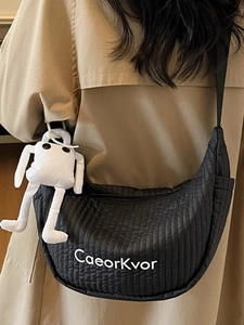 Quilted black crescent crossbody bag with cute robot charm and branded logo detail