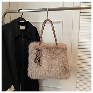 Detailed close-up of fluffy light coffee plush tote bag with woven handle and charm