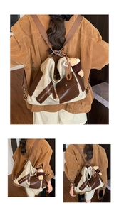 Detail view of large beige canvas tote bag with brown leather trim and multi-pocket design