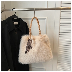 Detail of plush faux fur tote bag featuring brown woven leather handles and Fancy tag
