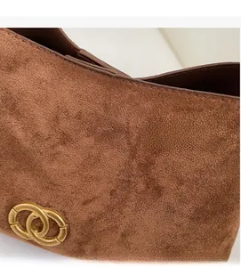 Detailed close-up of brown suede fabric texture and double ring gold metal buckle
