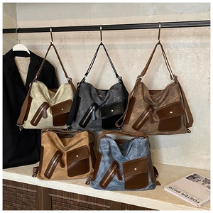 Detail view of five colors of vintage canvas tote bags with leather patchwork accents