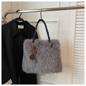 Detail of grey plush faux fur tote bag with spiral cord handles and metal charms