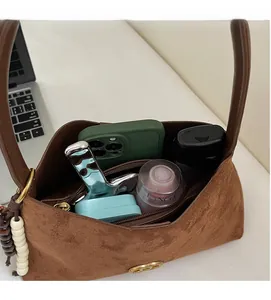 Macro shot showing the spacious interior of a brown suede bag with daily essentials