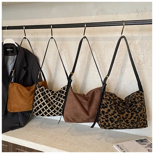 Detail view of four large suede hobo bags in various colors and trendy animal patterns