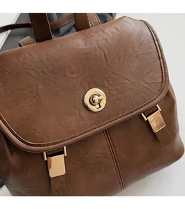Detail view of vintage dark brown faux leather backpack with golden metallic twist lock