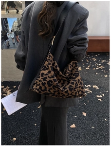 Close-up of leopard print suede hobo bag with adjustable leather strap and metal buckle