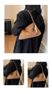 Detail view of vintage brown suede underarm bag featuring colorful beads and gold metal logo