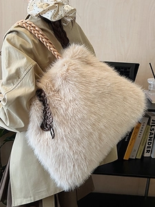 Faux fur tote bag with woven leather strap shown on shoulder in minimalist interior