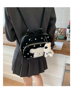 Detailed view of polka dot backpack in shiny finish with a cute plush dog pendant charm