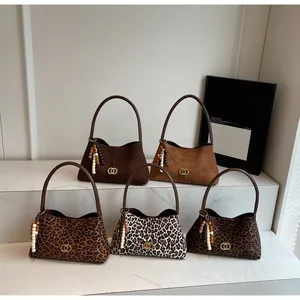 Detail view of five retro half-moon armpit bags in solid colors and leopard prints