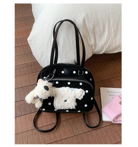 Polished black tote bag featuring white polka dots and a cute plush dog pendant