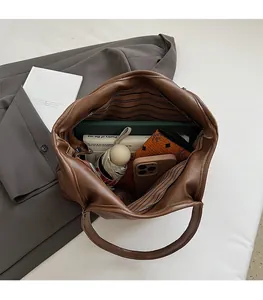 Vue de dessus de l'intérieur spacieux du sac marron avec doublure rayée et rangements