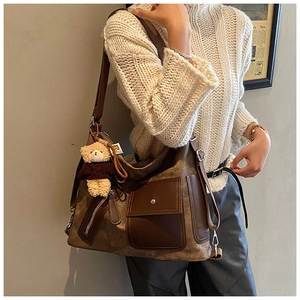 Close-up of vintage brown tote bag texture and cute bear plush charm detail