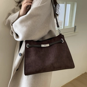 Detailed view of vintage frosted leather tote bag with metal twist lock and shoulder strap