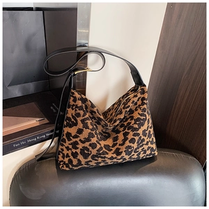 Detail shot of leopard print suede hobo bag with black leather strap and gold hardware