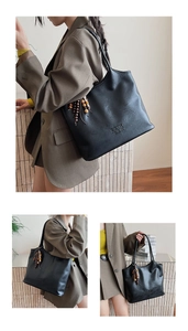 Détail du grand sac cabas noir en similicuir avec pompon en bois et texture gaufrée