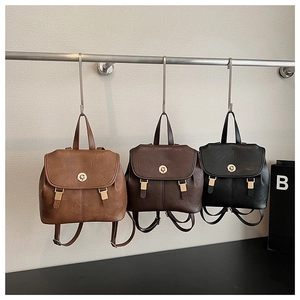 Detailed view of vintage leather backpacks in brown and black with metal buckle closure