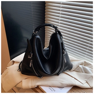 Close-up of litchi texture black tote bag with silver zippers on a blazer