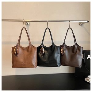 Détail de grands sacs fourre-tout rétro en trois couleurs avec breloques en bois