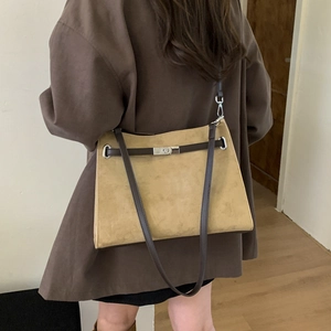 Detail view of large frosted leather tote bag with silver clasp shown on model