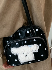 Chic black polka dot handbag featuring a cute plush animal patch for a stylish look