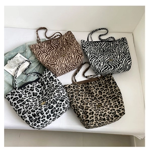 Close-up of four tote bags featuring tiger, zebra, and leopard animal prints in a macro view
