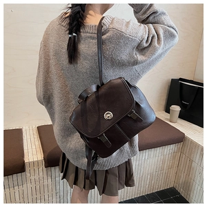 Rear view of a model wearing the dark brown vintage backpack in a minimalist cafe