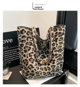 Detail view of leopard print tote bag with soft suede texture and gold metal logo plaque