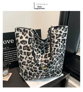 Detailed view of leopard print tote bag with a golden handmade metal plaque logo