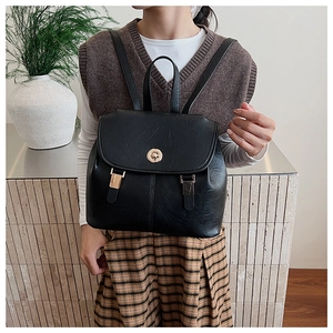Detail of black vintage PU leather backpack with golden rotary lock and buckle