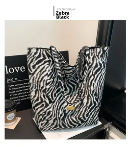 Detailed view of large zebra pattern tote bag with high quality metal hardware nameplate