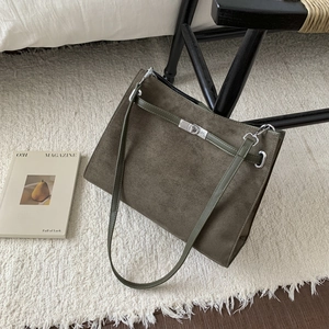 Detail of olive green frosted leather tote with metallic silver twist lock closure